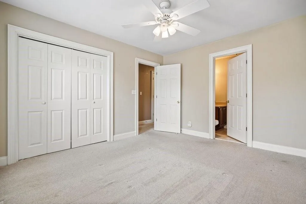 Unfurnished bedroom with light colored carpet, ceiling fan, and a closet