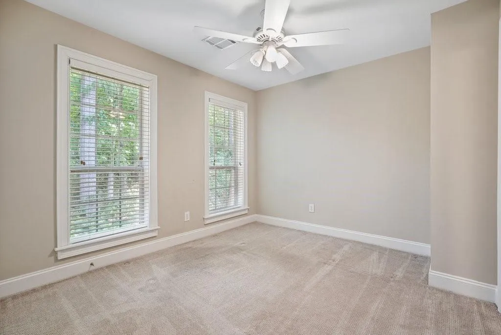 Carpeted spare room featuring ceiling fan