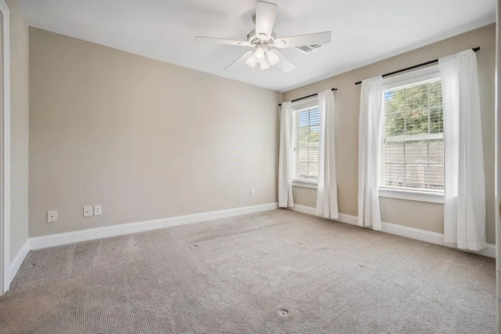 Unfurnished room featuring ceiling fan and carpet flooring