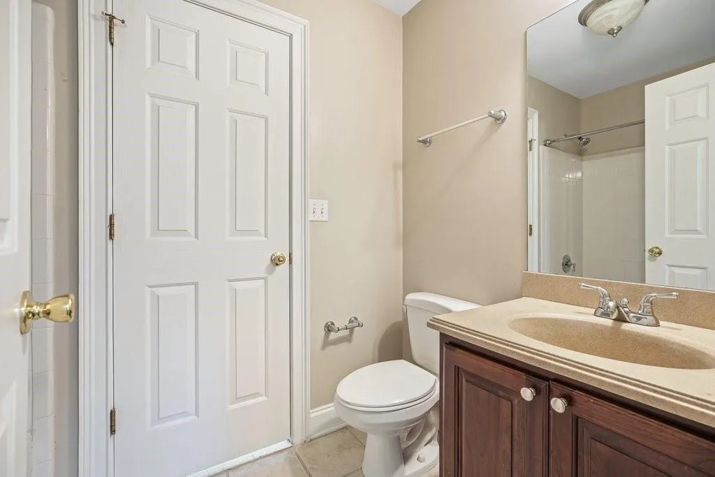 Bathroom with tile flooring, toilet, and large vanity