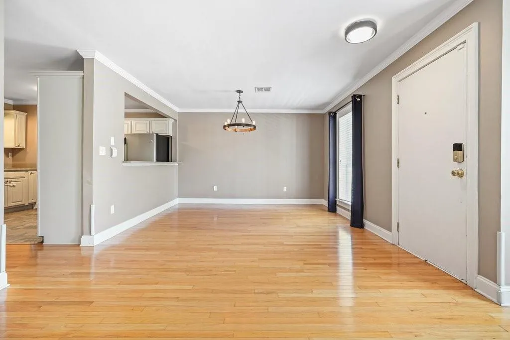 Empty room featuring ornamental molding and light hardwood / wood-style flooring