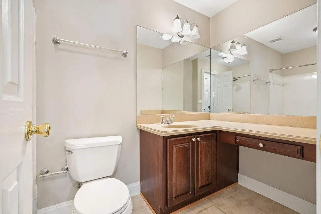 Bathroom featuring toilet, tile floors, and vanity