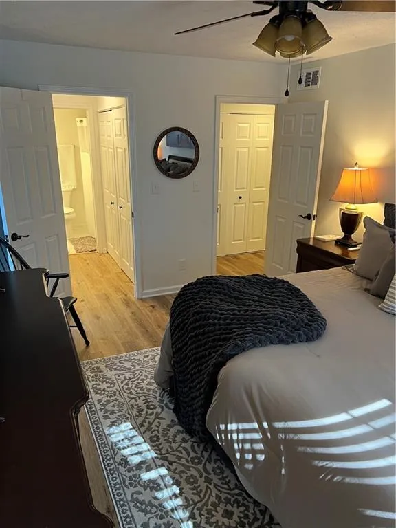 Bedroom with light wood-style floors, a closet, and a ceiling fan