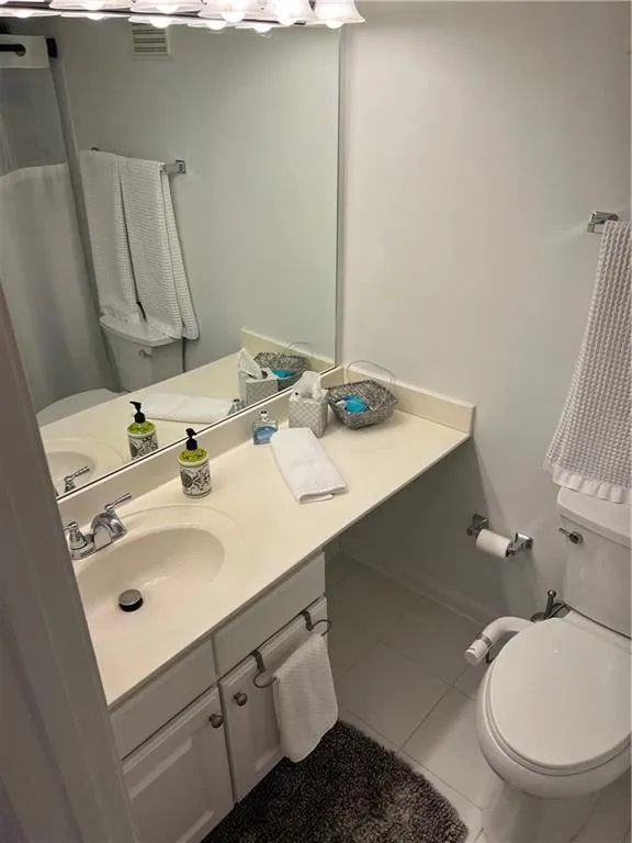 Bathroom with light tile patterned flooring and vanity