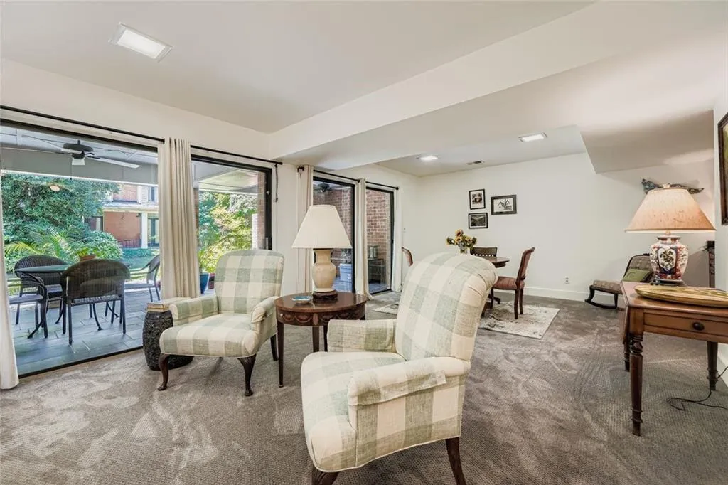 Sitting room featuring dark carpet and ceiling fan