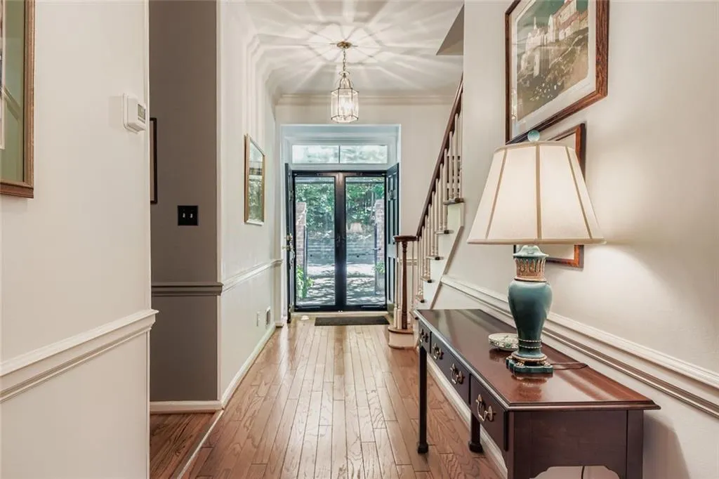 Entryway featuring french doors, light wood-style floors, stairway, and crown molding