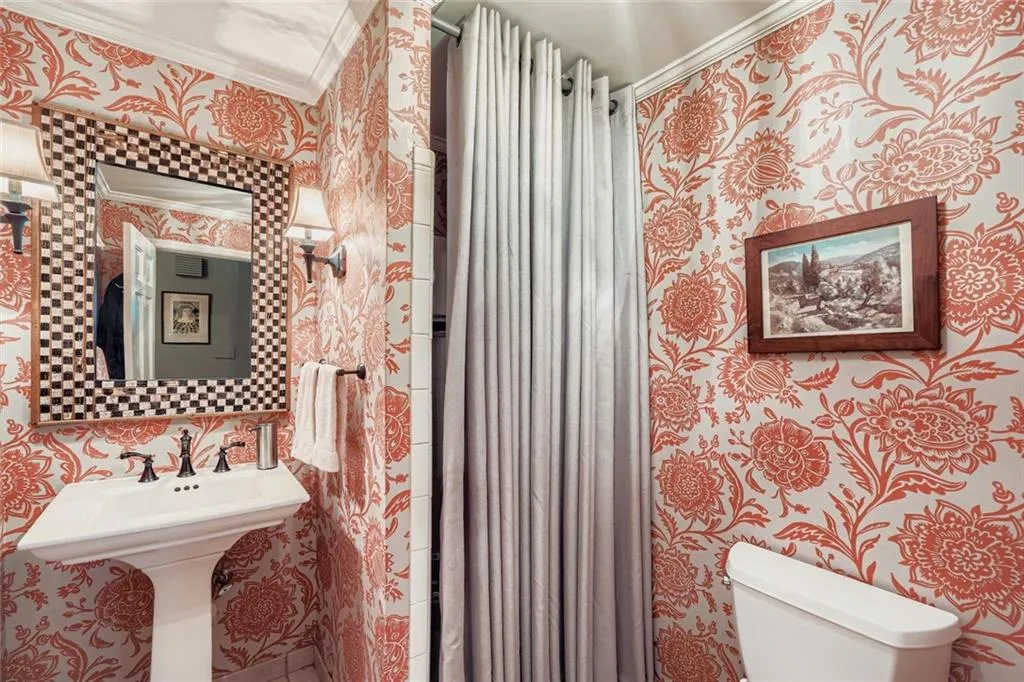 Full bath featuring wallpapered walls, a shower stall, and crown molding