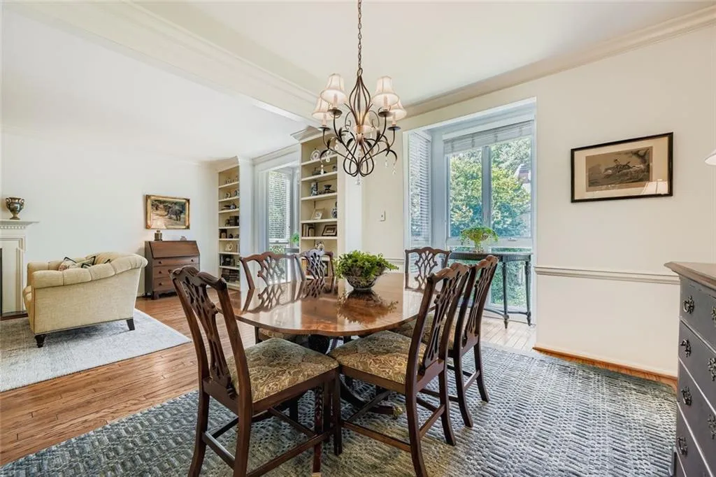 Dining space with ornamental molding, wood finished floors, and a chandelier
