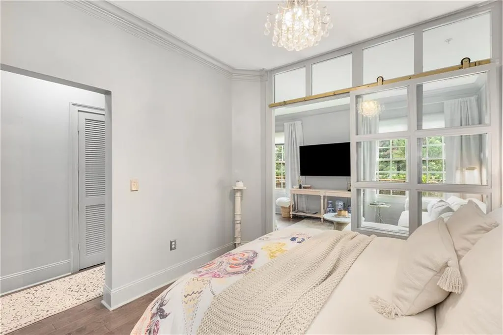 Bedroom featuring dark wood-style floors, a chandelier, and crown molding