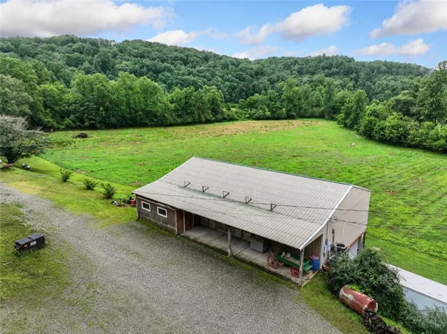 Barn structure featuring a corrugated metal roof, wood siding, and an open covered porch