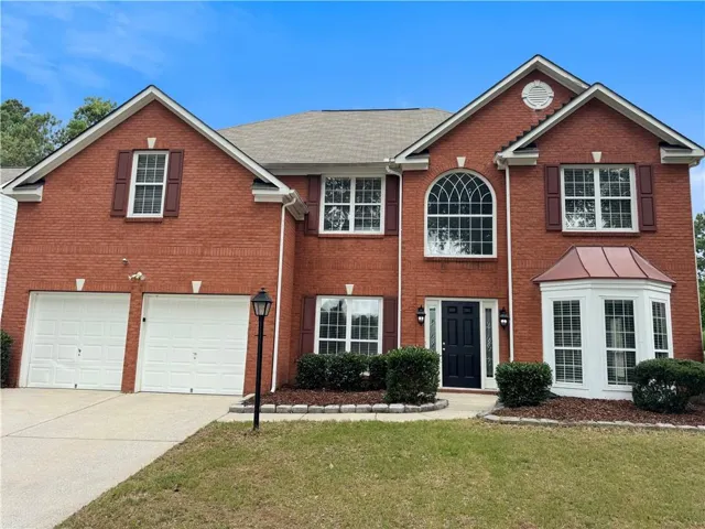 Red brick exterior featuring a multi-gabled roofline and white trim accents