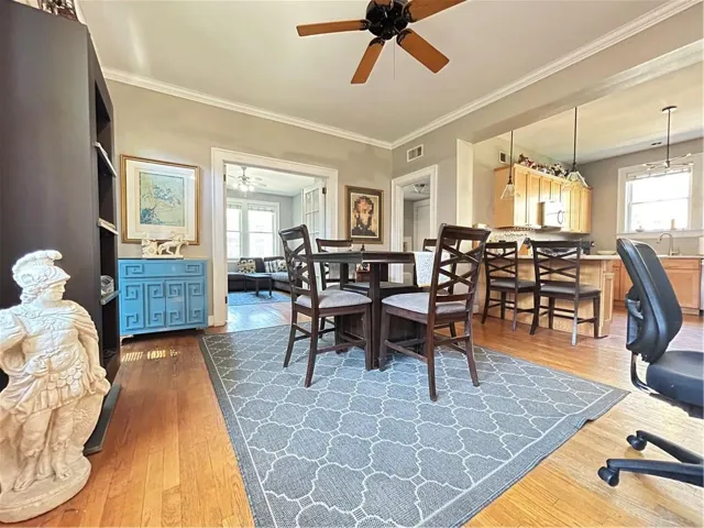 Dining area with light wood-type flooring, ornamental molding, and ceiling fan