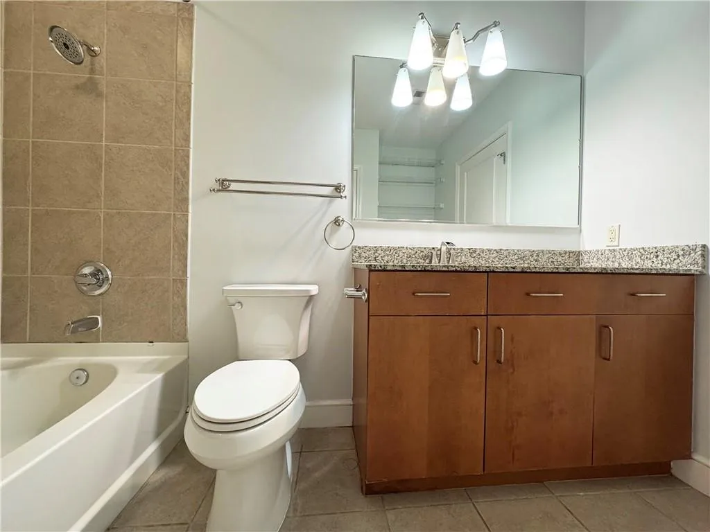 Full bathroom featuring vanity,  shower combination, and light tile patterned flooring