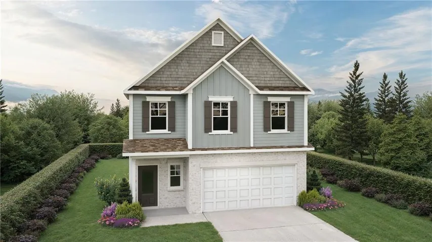 Two-story residence featuring a two-car garage and a combination of shingle and siding exterior finishes