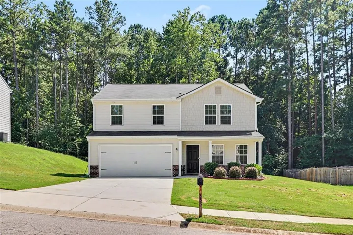 Two-story residence featuring light-colored siding and a covered entry