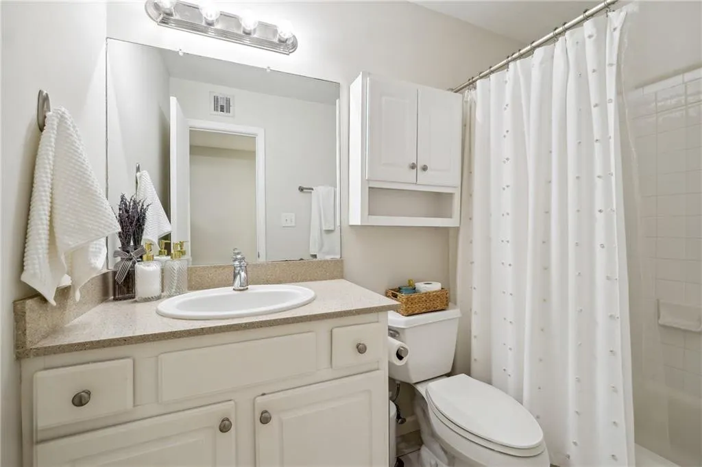 Full extra bathroom with shower / bath combo, toilet, and vanity