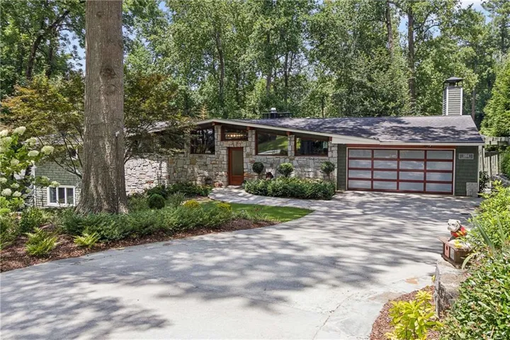 A striking Mid-Century Modern tucked beneath a canopy of mature trees in the heart of Buckhead's Pine Hills.