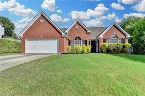 Brick-front exterior featuring a gabled roofline and attached garage