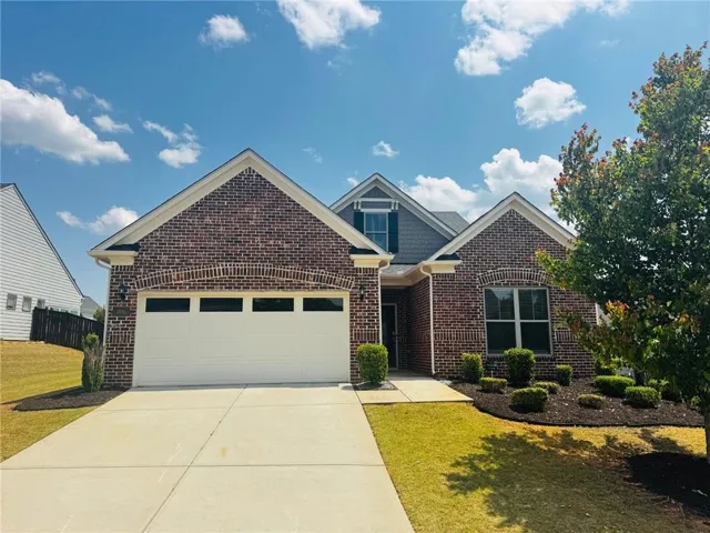 Brick and siding exterior featuring an attached two-car garage with transom windows