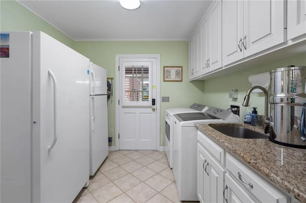 This is truly one of the coolest things about this house.  So much cabinetry in this large laundry room.  This is the door into the garage that has a climate controlled massive closet for storing all of your extras.