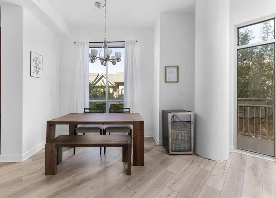 Dining space featuring wine cooler, light wood-style flooring, and a chandelier