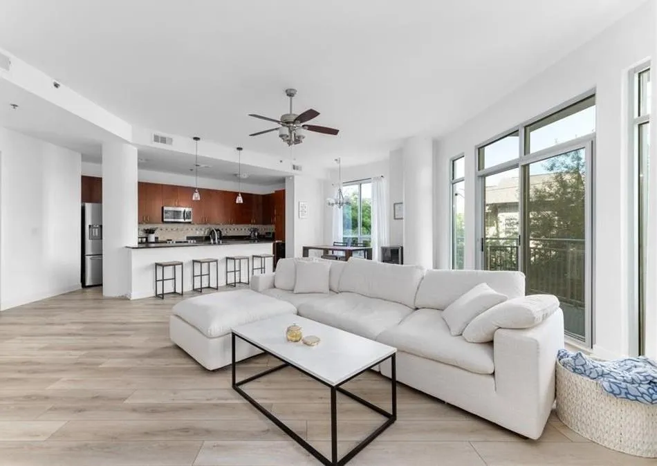 Living room featuring light wood finished floors, a chandelier, and ceiling fan