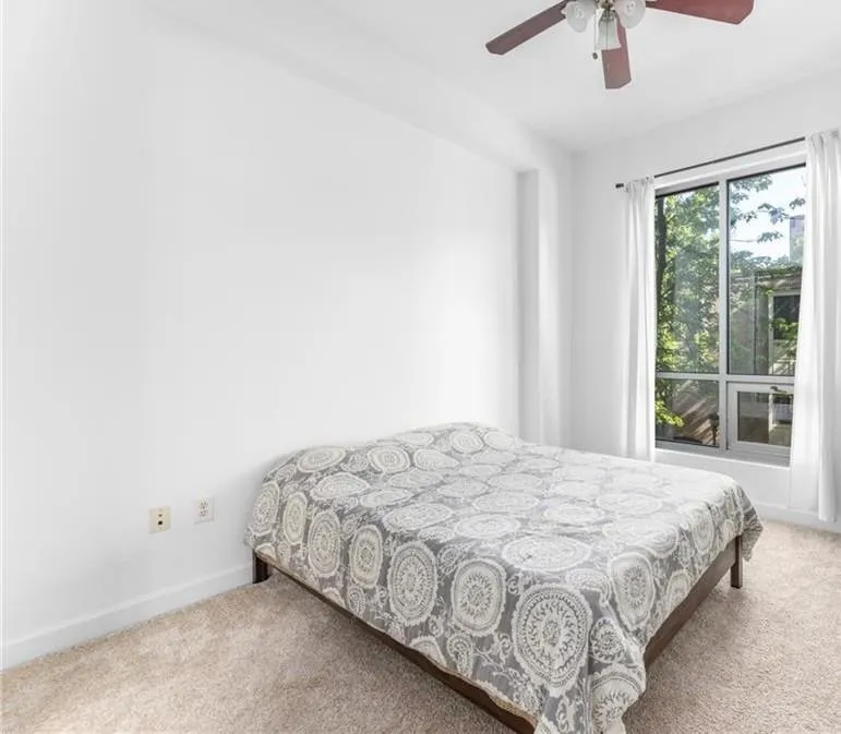 Carpeted bedroom featuring baseboards and a ceiling fan