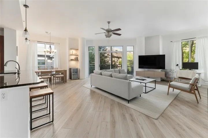 Open-concept living space featuring wood-finish flooring, recessed lighting, and a ceiling fan