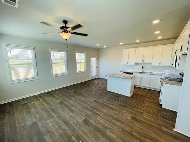 Open-concept layout featuring wood-finish flooring and a ceiling fan