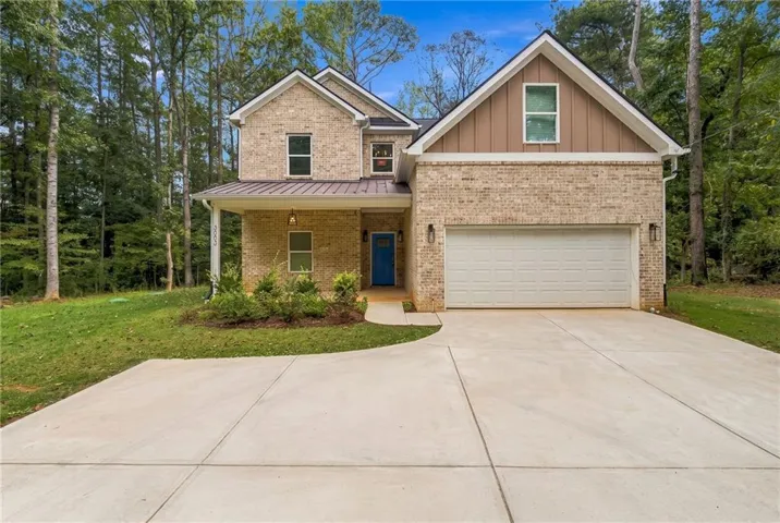 Brick and siding exterior with a covered entry, attached two-car garage, and concrete driveway