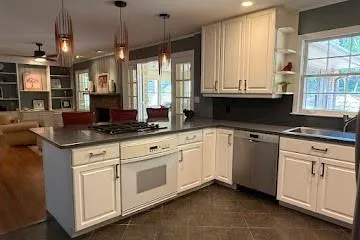 Kitchen with a peninsula, stainless steel appliances, ceiling fan, open shelves, and white cabinets