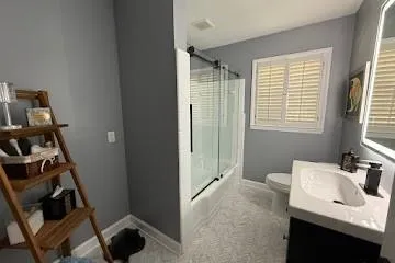 Full bath with marble flooring, tub, shower stall and vanity