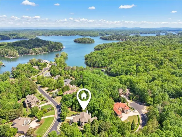 Aerial perspective showcasing a residential area amidst lush green landscapes and expansive bodies of water