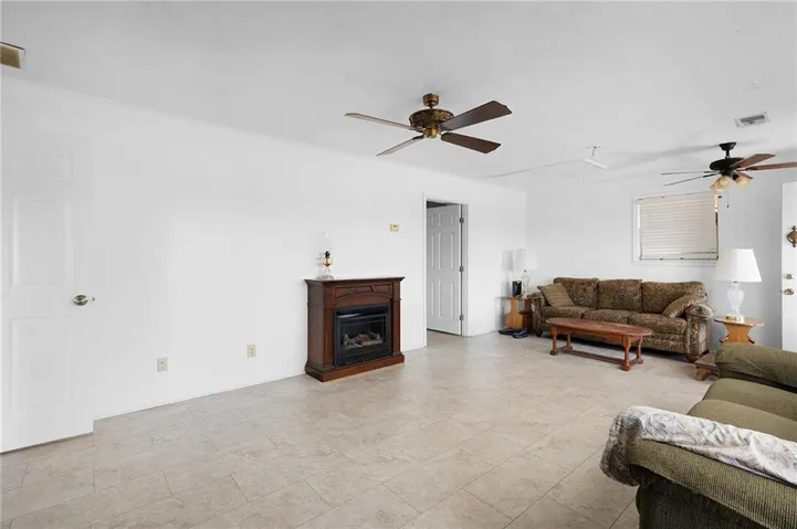 Tile flooring throughout, white walls, and multiple ceiling fans