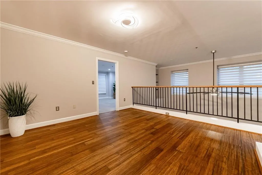 Spare room featuring wood finished floors and ornamental molding