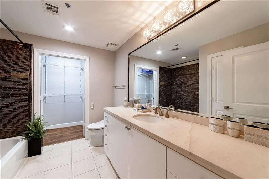 Bathroom with tile patterned flooring, vanity, recessed lighting, and a spacious closet