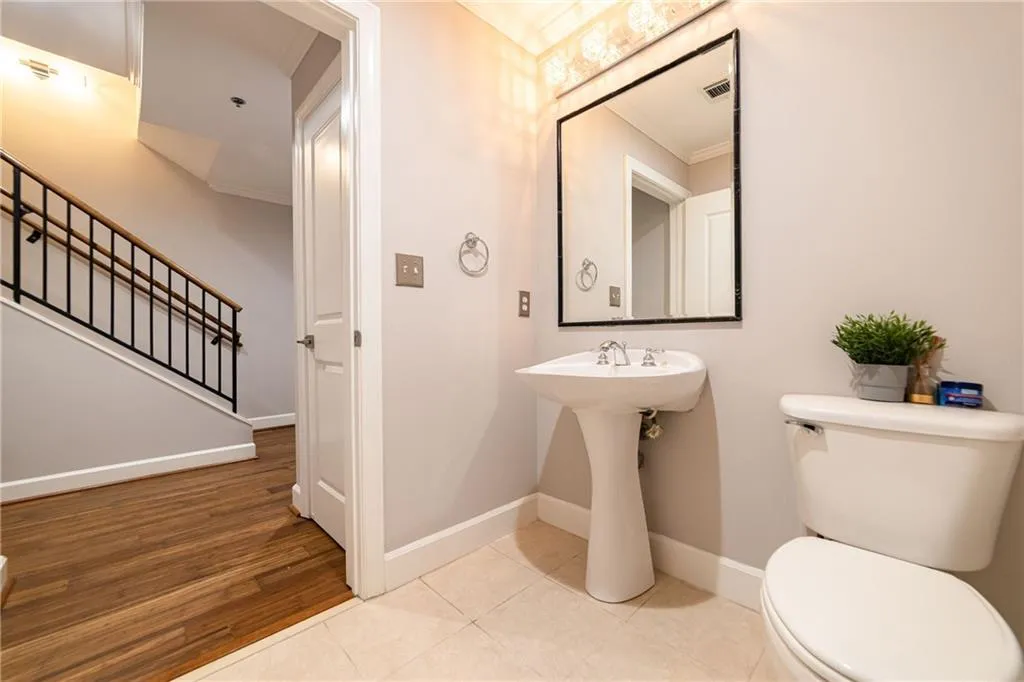 Half bath with crown molding and wood finished floors
