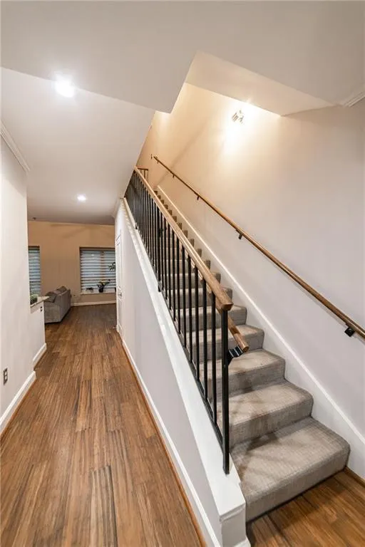 Stairs featuring wood finished floors and recessed lighting