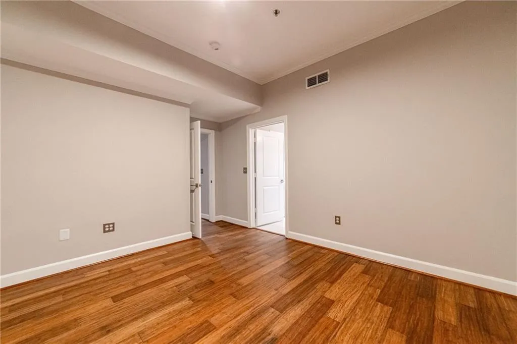 Empty room with ornamental molding and light wood-style floors