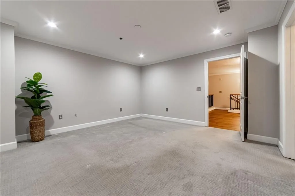 Empty room featuring light colored carpet, recessed lighting, and ornamental molding