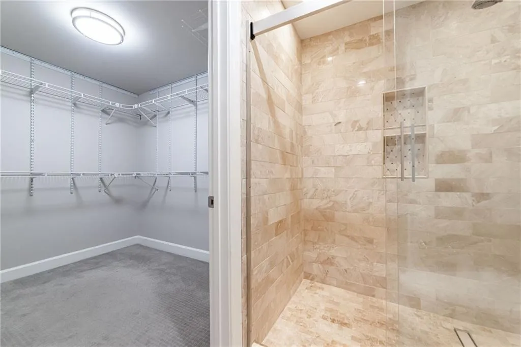 Full bathroom with a stall shower and a walk in closet