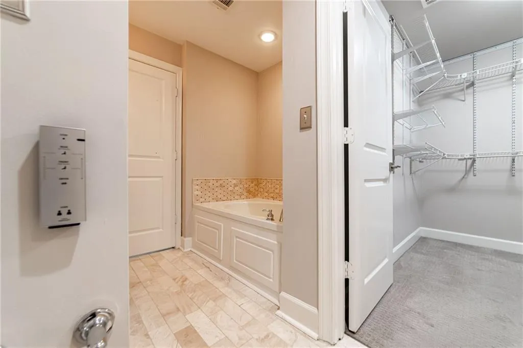 Bathroom with a garden tub and a walk in closet