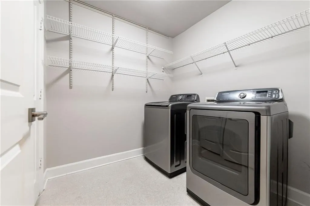 Washroom with separate washer and dryer and baseboards