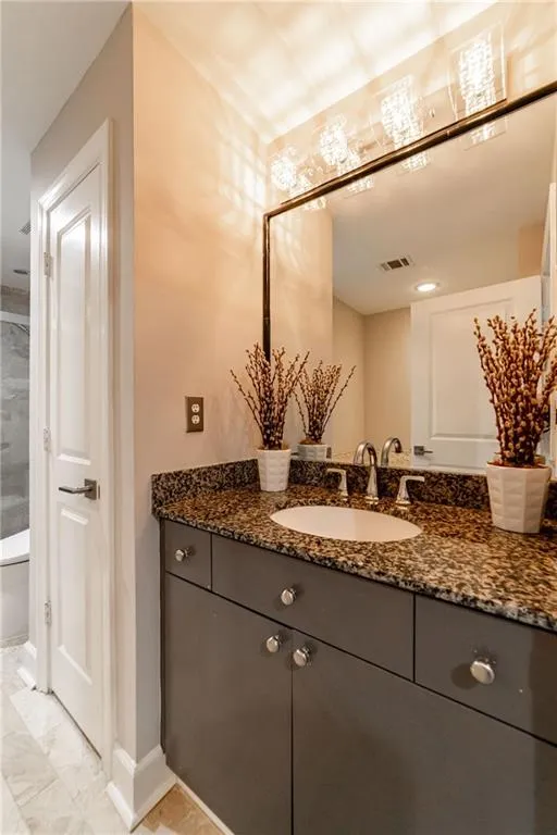 Bathroom with marble finish flooring and vanity