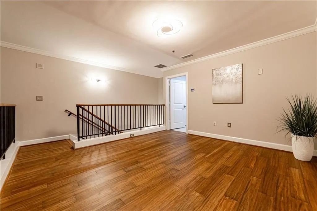 Empty room featuring crown molding and wood finished floors