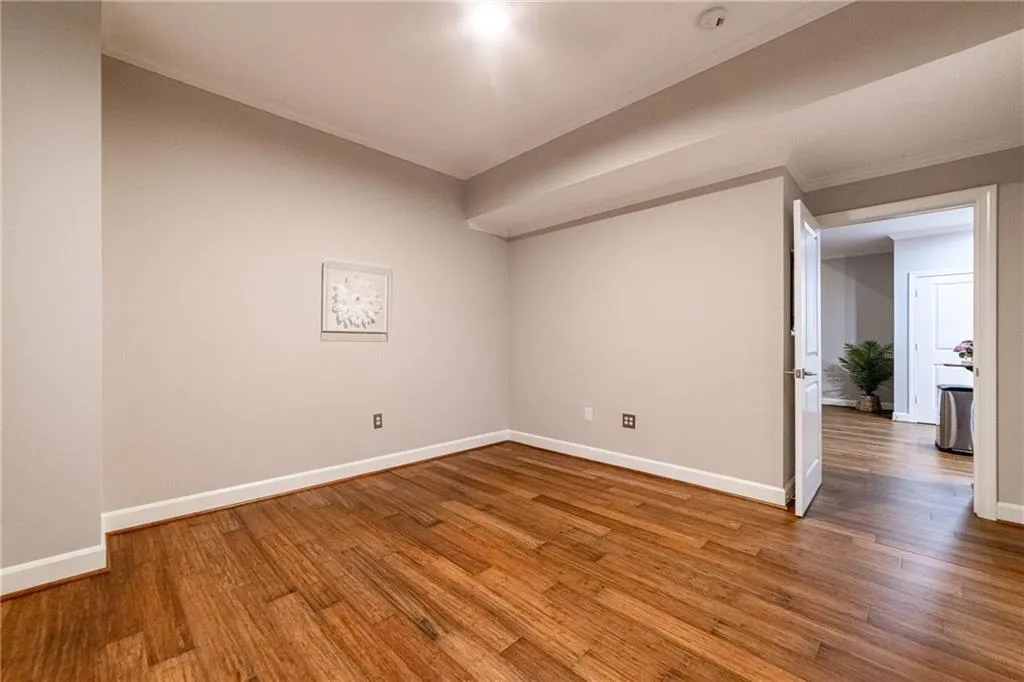Spare room featuring ornamental molding and wood finished floors