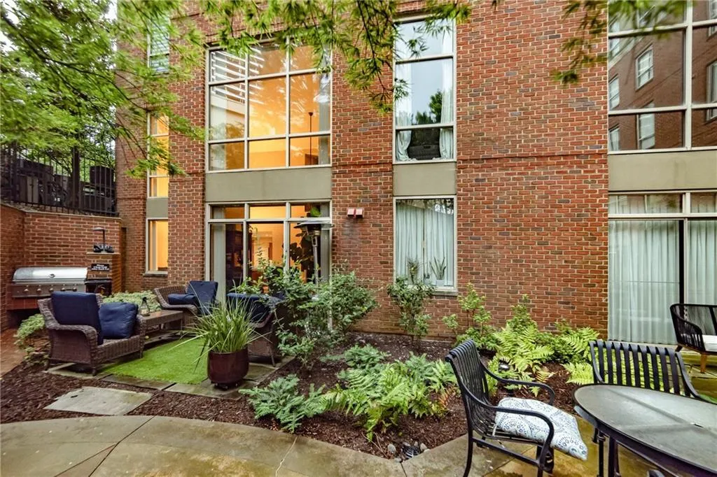 Rear view of house featuring brick siding, an outdoor hangout area, and a patio