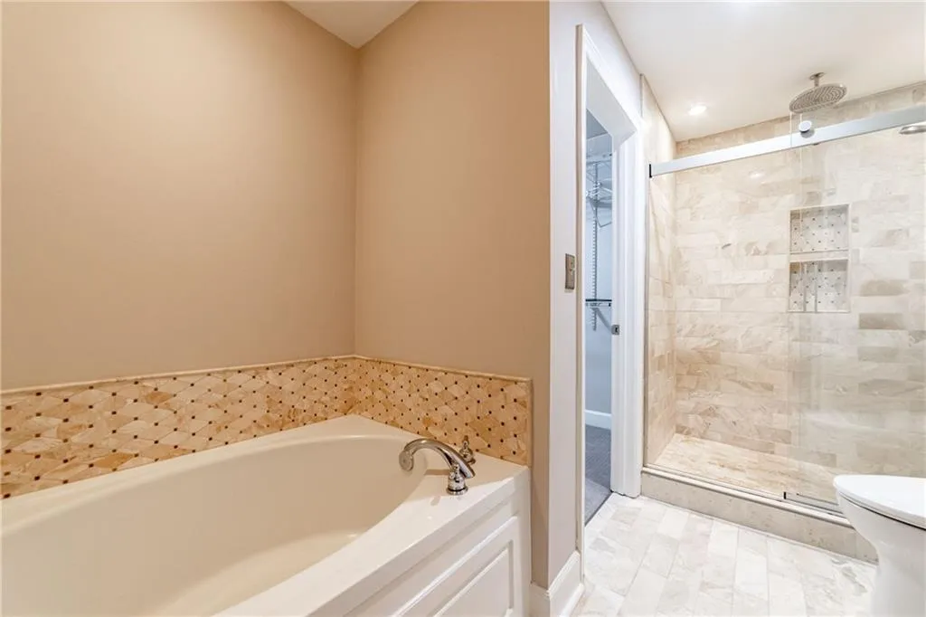Full bathroom featuring a bath and a stall shower