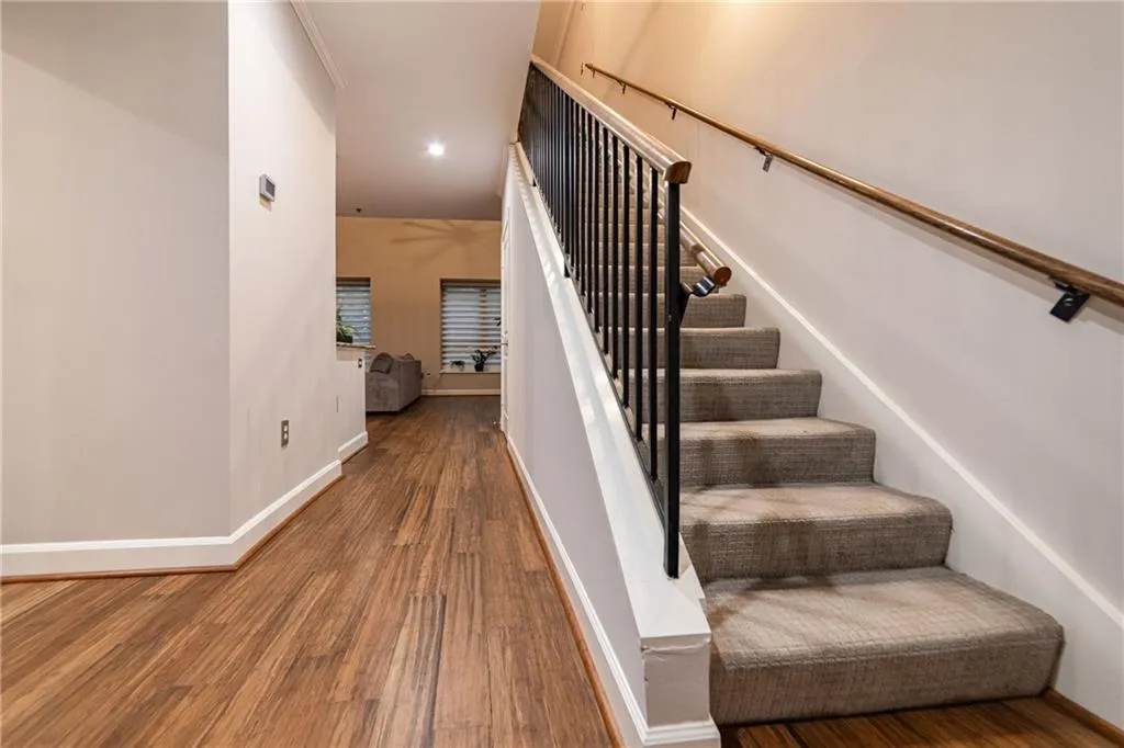 Staircase featuring wood finished floors and recessed lighting