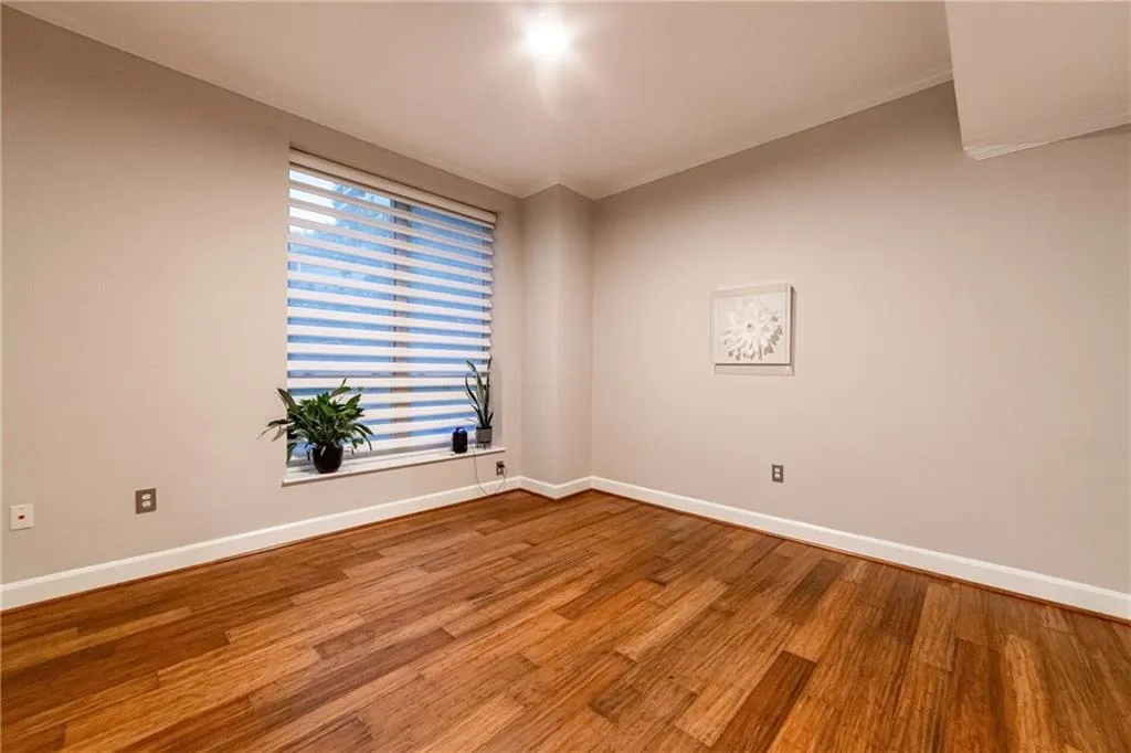 Empty room featuring ornamental molding and wood finished floors